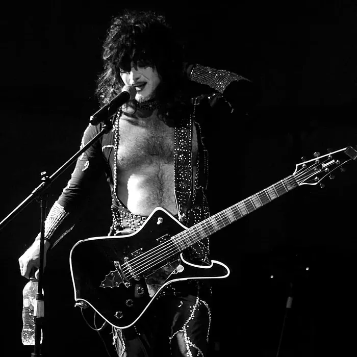 Alexis Lefno cantando y tocando la guitarra caracterizado como Paul Stanley