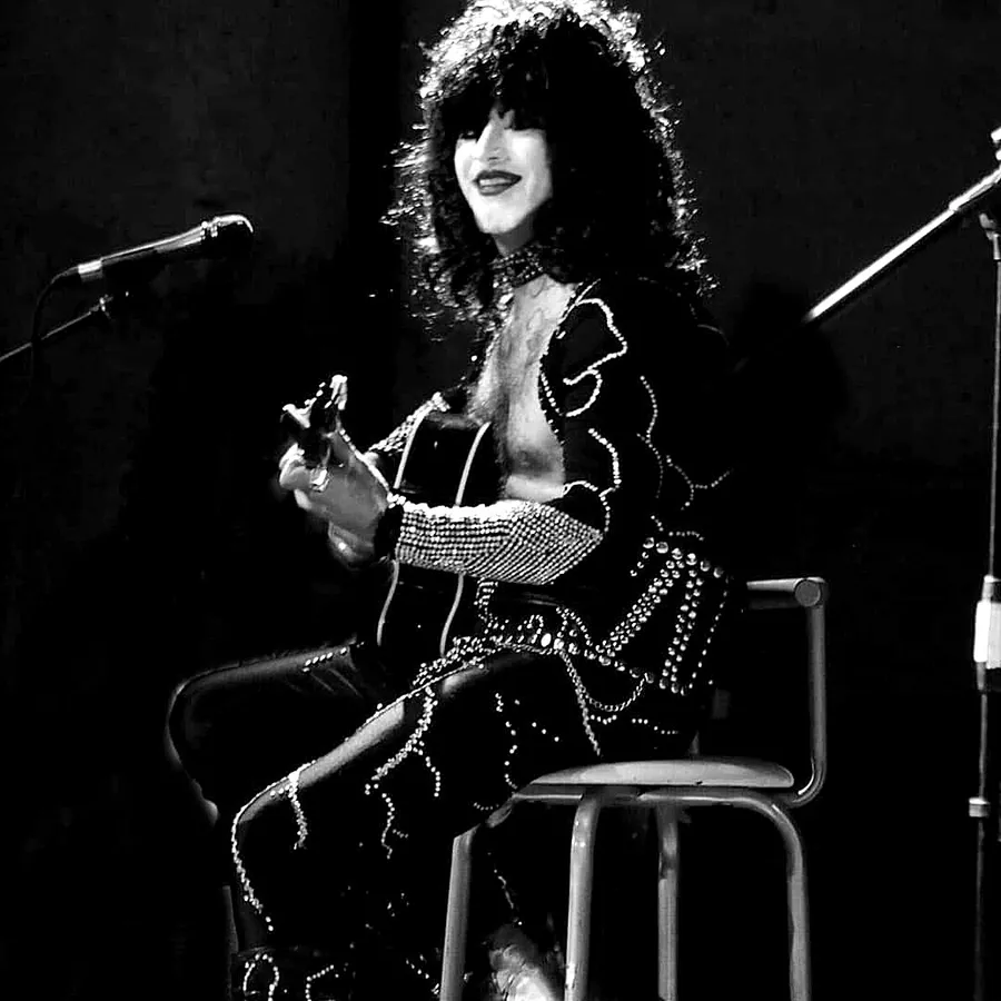 Alexis Lefno caracterizado como Paul Stanley, tocando la guitarra sentado en un banco