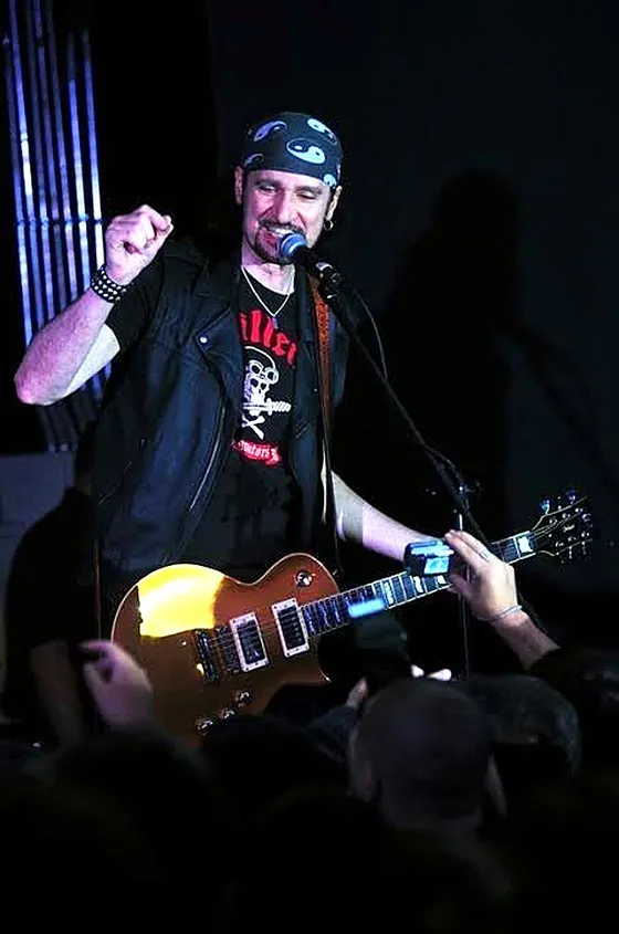 Bruce Kulick cantando y tocando la guitarra frente al público, en el concierto del Club 334 en Chile
