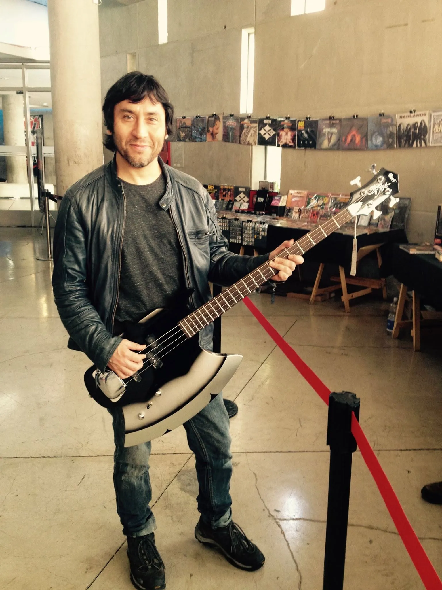Claudio Narea con su bajo, junto a un stand de memorabilia de KISS