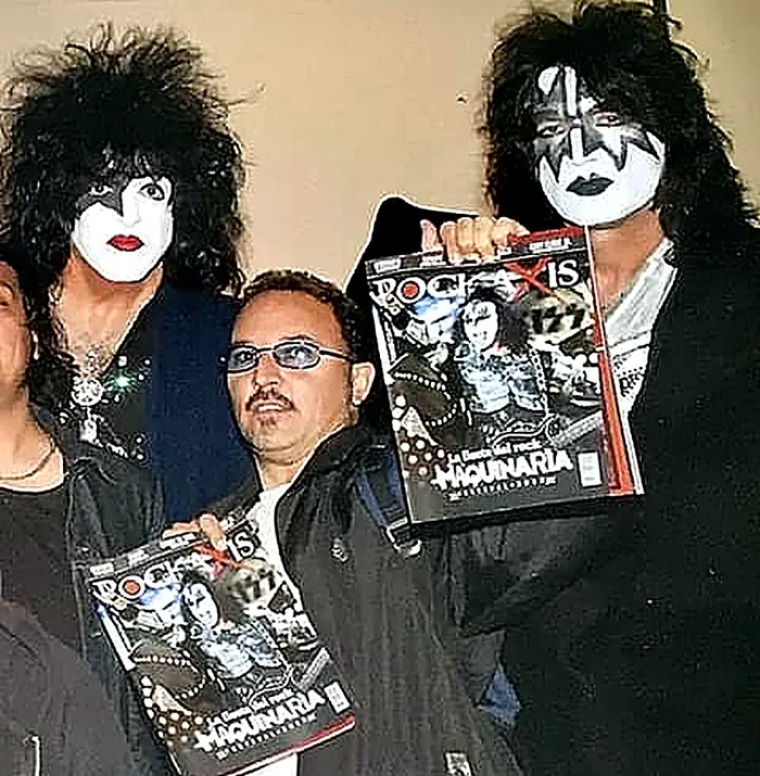 Cote Hurtado con Paul Stanley y Ace Frehley, sosteniendo revistas Rockaxis