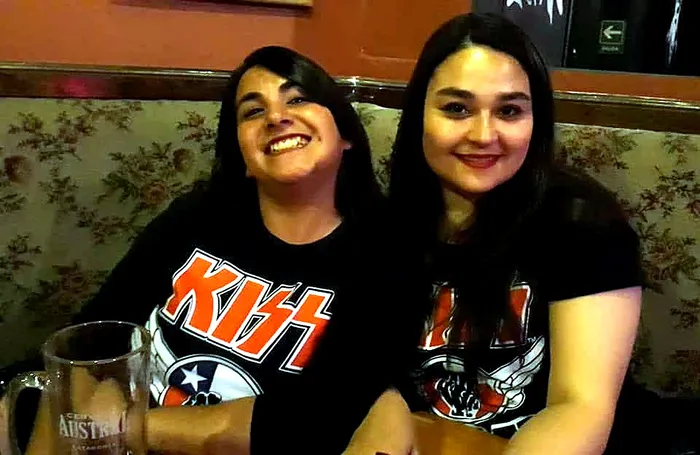 Dos fans de KISS Army Chile sonriendo con sus poleras
