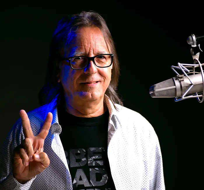 Hernán Rojas haciendo la señal de paz frente a un micrófono de radio