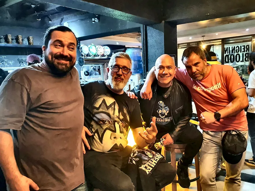 Cuatro kisseros posando en la barra de Chargobar, uno con una polera del maquillaje de Ace