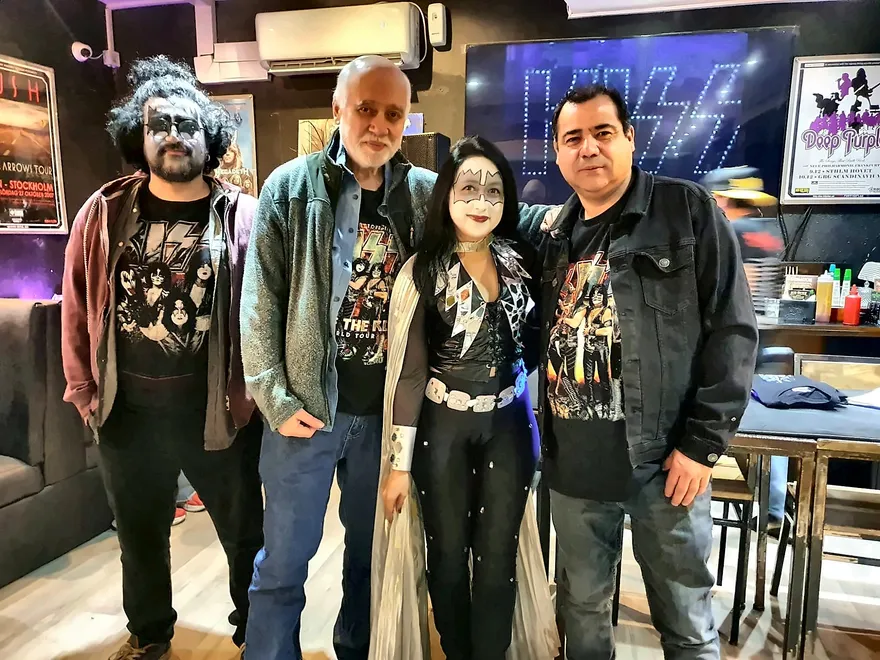 Fan caracterizada como Ace Frehley junto a tres asistentes con poleras de KISS