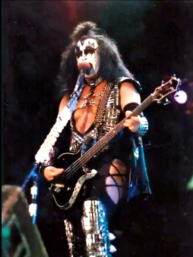 Gene Simmons tocando el bajo sobre el escenario, con maquillaje y vestuario